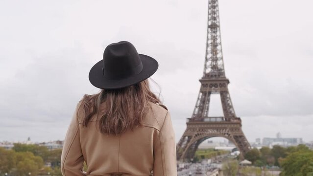 Footage of young tourist woman taking a photo of Eiffel Tower. 