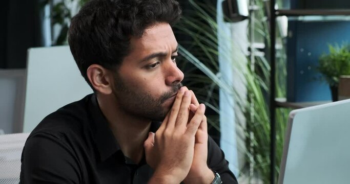 Middle Eastern entrepreneur appears flustered and distraught while working on computer. His expression reflects the challenges and pressures that can arise during the course of business.