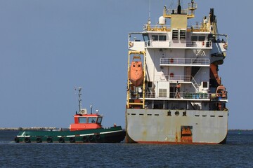 Harbor tugboat assists a Cargo ship at the harbor  © Douglas