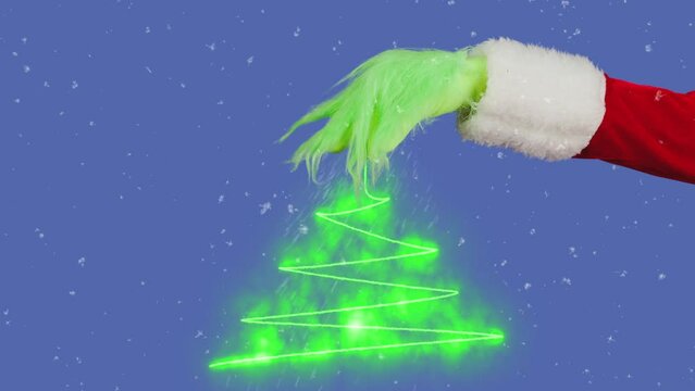 Green hairy Grinch hand and Christmas tree graphic on isolated blue background. A place for your advertisement. Gift snatcher cosplay. New Year celebration concept. Blue screen, chroma key.