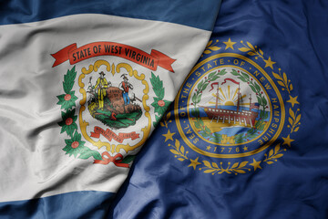 big waving colorful national flag of new hampshire state and flag of west virginia state.