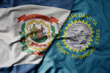 big waving colorful national flag of south dakota state and flag of west virginia state .