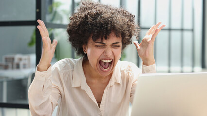 a girl works in an office at a laptop. gets angry, expresses dissatisfaction