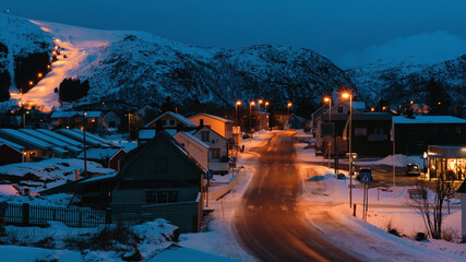 Small village with snowy mountains during evening time