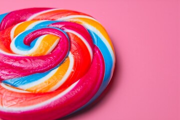 Colourful and swirly candy lollipop on a pink background