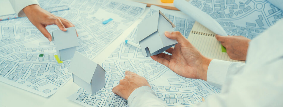 Worker, architect and engineer work on real estate construction project oratory planning with cartography and cadastral map of urban town area to guide to construction developer business plan of city