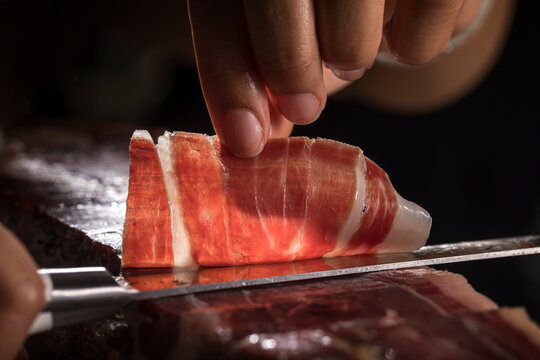 Jam&oacute;n ib&eacute;rico de bellota espa&ntilde;ol. Cortador de jam&oacute;n ib&eacute;rico cortando a mano loncha para degustar. T&iacute;pica loncha de jam&oacute;n ib&eacute;rico de gran calidad con sus vetas y grasa.