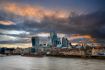 Fototapeta premium A view over the London skyline with the Thames river in the foreground and a beautiful sunset sky