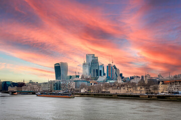 A view over the London skyline with the Thames river in the foreground and a beautiful sunset sky