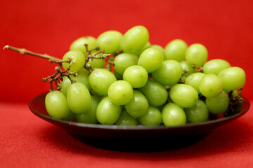 Fresh Green Grapes on red background. healthy fresh grapes concept