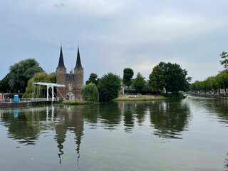 Lake reflecting Oostpoort historical landmark on a gloomy day