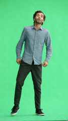 Fototapeta premium full-length portrait of a young man. standing isolated on green background