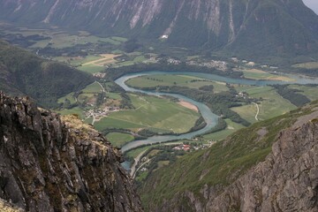 High-angle shot of the winding river in Rauma Norway surrounded by big mountains - Powered by Adobe