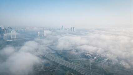 Aerial view of a modern city against the gradient blue sky on a foggy day