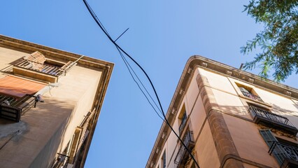 Low angle of old buildings' roof corners against a blue sky under the sun