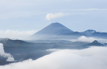 mountain in winter with foggy clouds