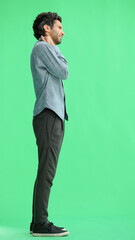 young man in full growth. isolated on green background demonstrates back pain