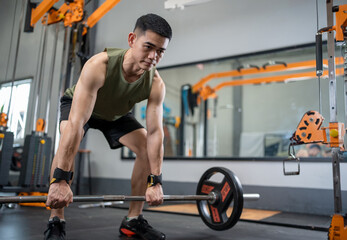 Fototapeta na wymiar Young man lifting weights and exercising