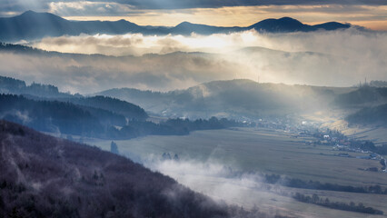 Mountainous landscape with misty valleys at dramatic light in sunset. Northwestern Slovakia, Europe.