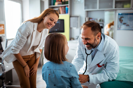 Pediatrician Interacting with Child and Mother During Consultation