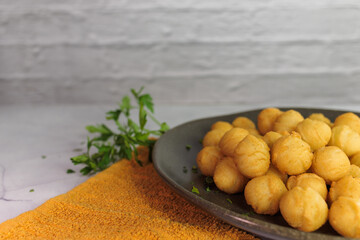 Duchess potatoes, homemade, typical in chile, with parsley, in a round plate and ocher kitchen...