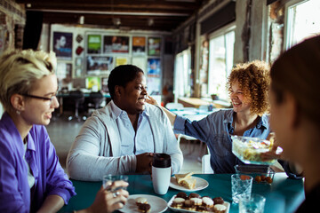 Diverse young colleagues eating together on break in the office