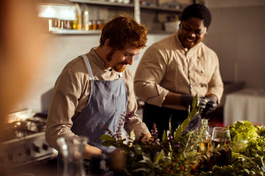 Professional cooks in uniform making meal at restaurant kitchen