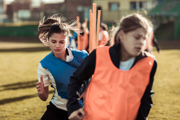Young female soccer player having practice with team in stadium