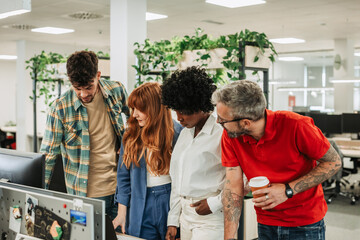 Diverse colleagues discussing work while working together in the modern office