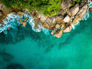 Aerial view Top down seashore. Waves crashing on rock cliff. Beautiful dark sea surface in sunny day summer background Amazing seascape top view seacoast at Anse Solei Beach, Mahe Seychelles