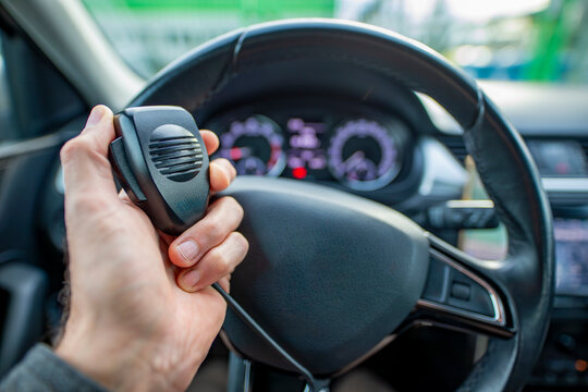CB radio in a passenger car. A radio microphone held in the hand of a car driver.