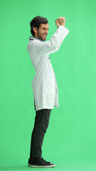 Fototapeta na wymiar male doctor in a white coat on a green background rejoices. raised his hands up