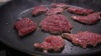 Dolly shot of Raw Steaks Cooking on Nonstick Pan.