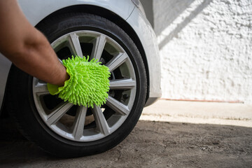 A Man Cleaning the Wheels of a Car with a Microfiber Wash Mitt. Car Detailing and Cleaning Concept...