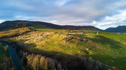 A tranquil outdoor landscape with green hills and a panoramic sky in Norway