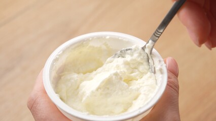 Close-up shot of Scooping Cream Cheese from Tub.