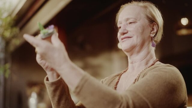 Artista senior, concentrada pintando um vaso de ceramica. Cinematico 4k.