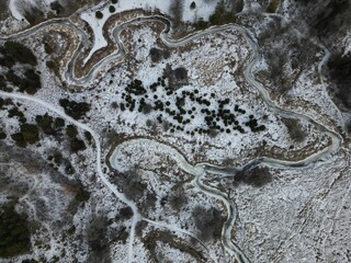 Aerial view of snow covered landscape surrounded by trees