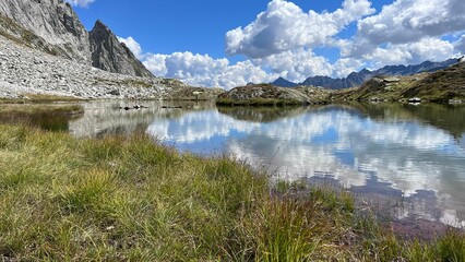 Small mountain lake hidden in the Swiss mountains surrounded by nature, near the Nufenen Pass