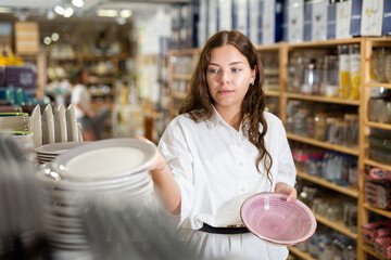 Consumer american woman buying plates for kitchen in the dishes shop