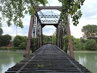 old train bridge over a slow moving river