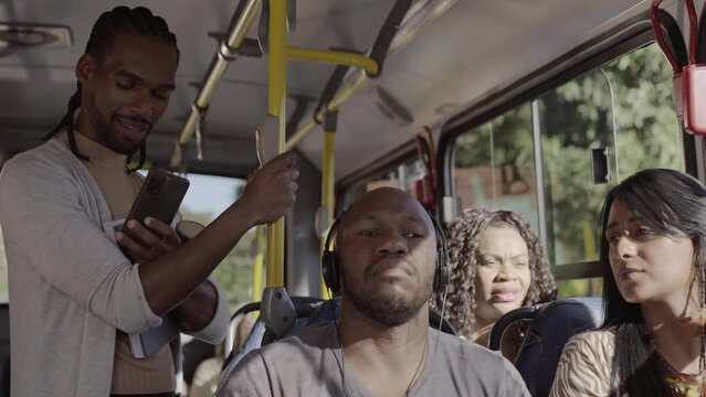 Passageiros multirraciais dentro do onibus em trajeto urbano. Cinematico 4k.
