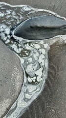 water pattern  flowing around a beach rock