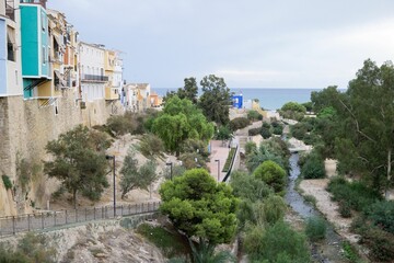 Fototapeta na wymiar Small river in Alicante between beautiful buildings and trees with the sea in the background, Spain