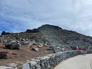 Pile of stones on top of a hill next to a construction site against a blue sky