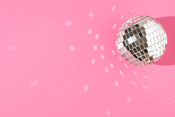 Disco ball on a pastel pink background. The concept of minimal entertainment. Flat lay.