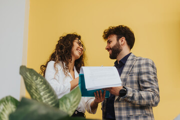 Young male employee flirting with his female colleagues while working together at modern office space.