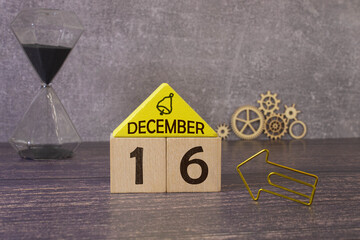 Cube shape calendar for December 16 on wooden surface with empty space for text