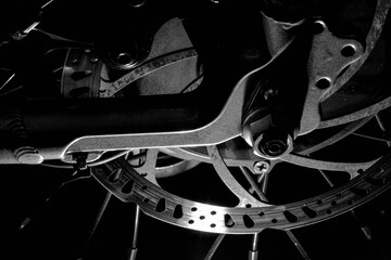 Grayscale closeup shot of details on the rear break of an electric bike