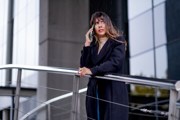 Fototapeta premium Phone talk of woman, urban backdrop, office.